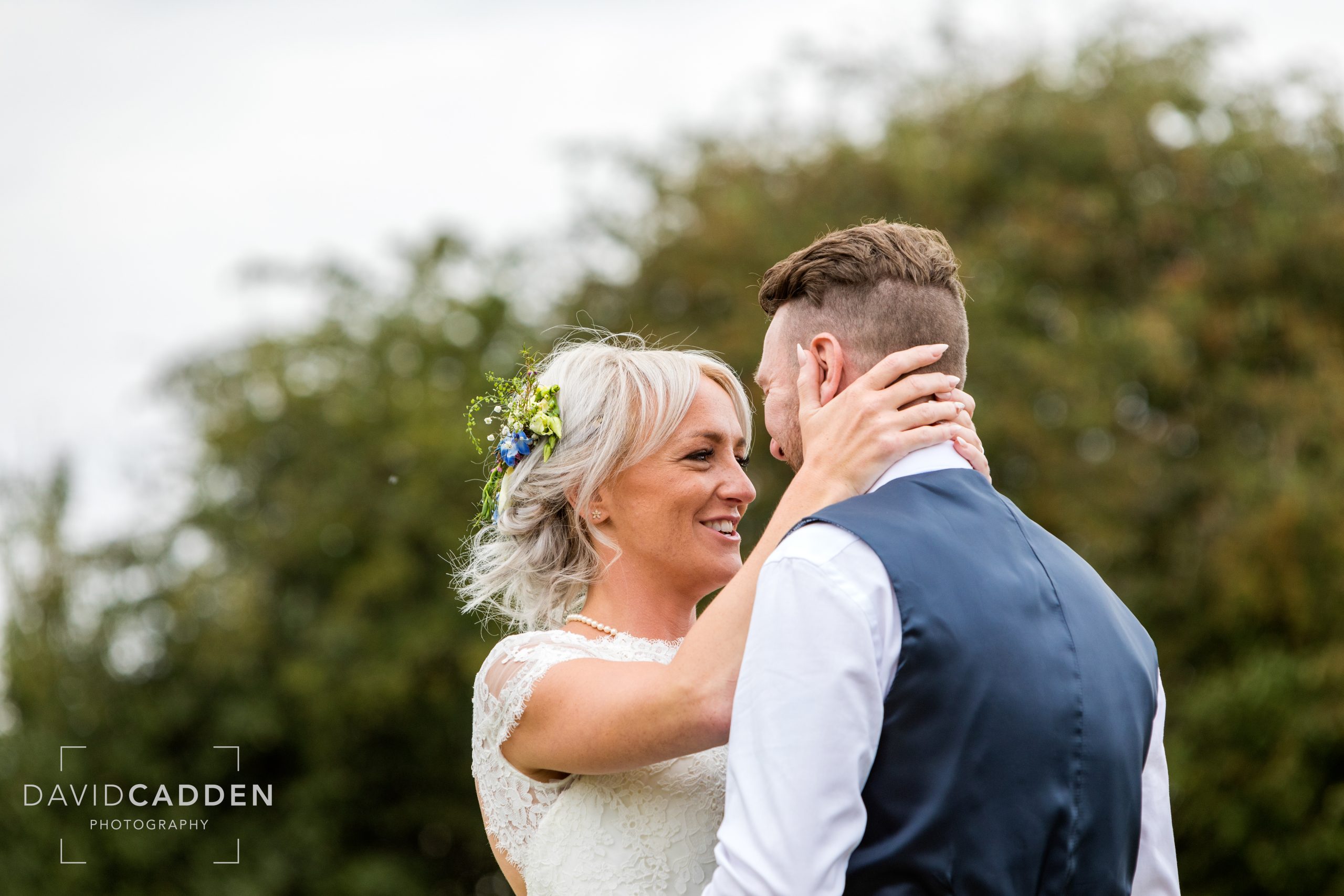 Bride holding her husband in a sweet embrace.