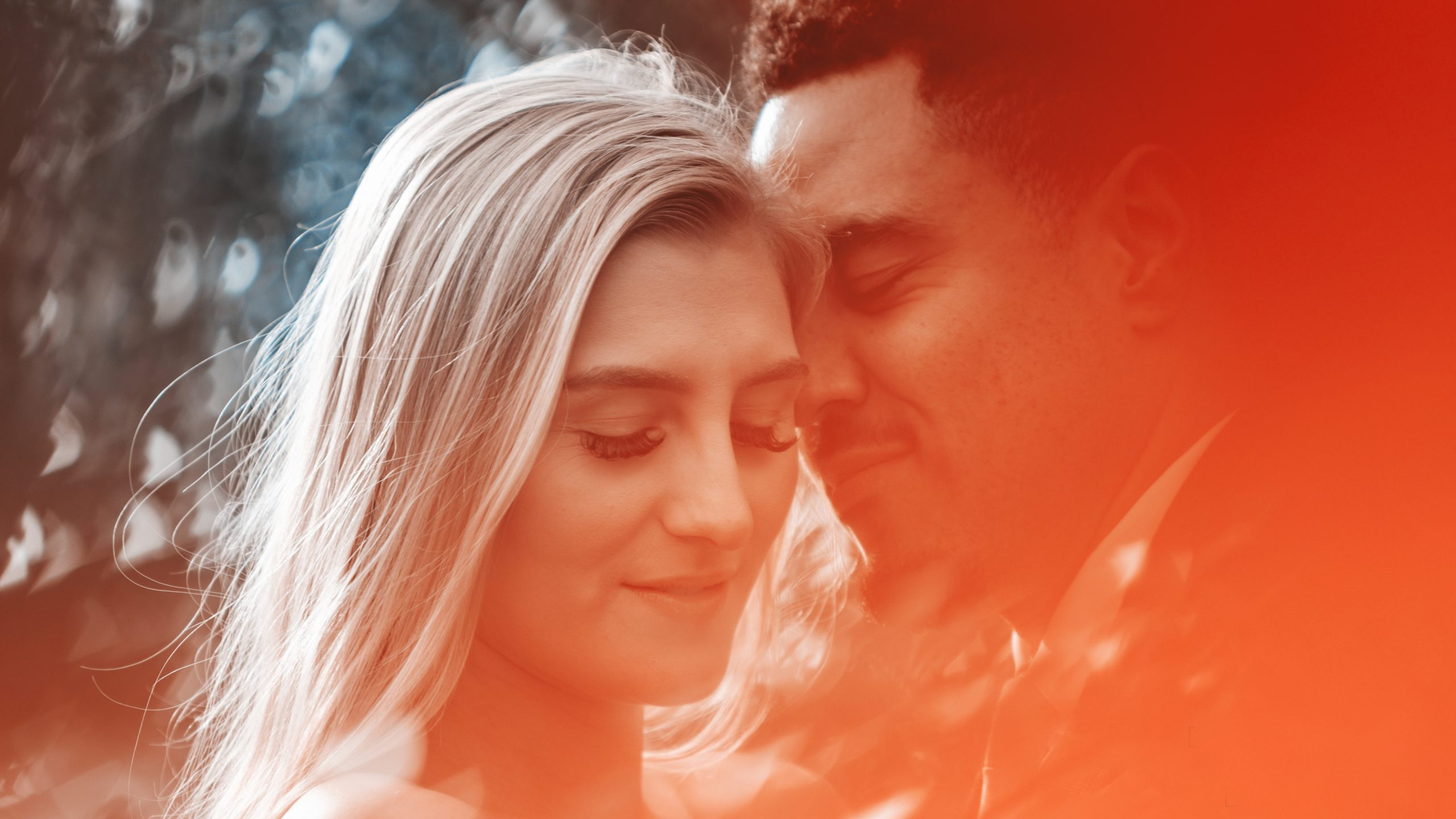 Close-up wedding portrait of a bride and groom surrounded by warm orange light